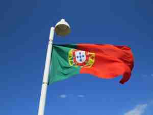 THE PORTUGUESE FLAG FLYING ON A FLAGPOLE.
